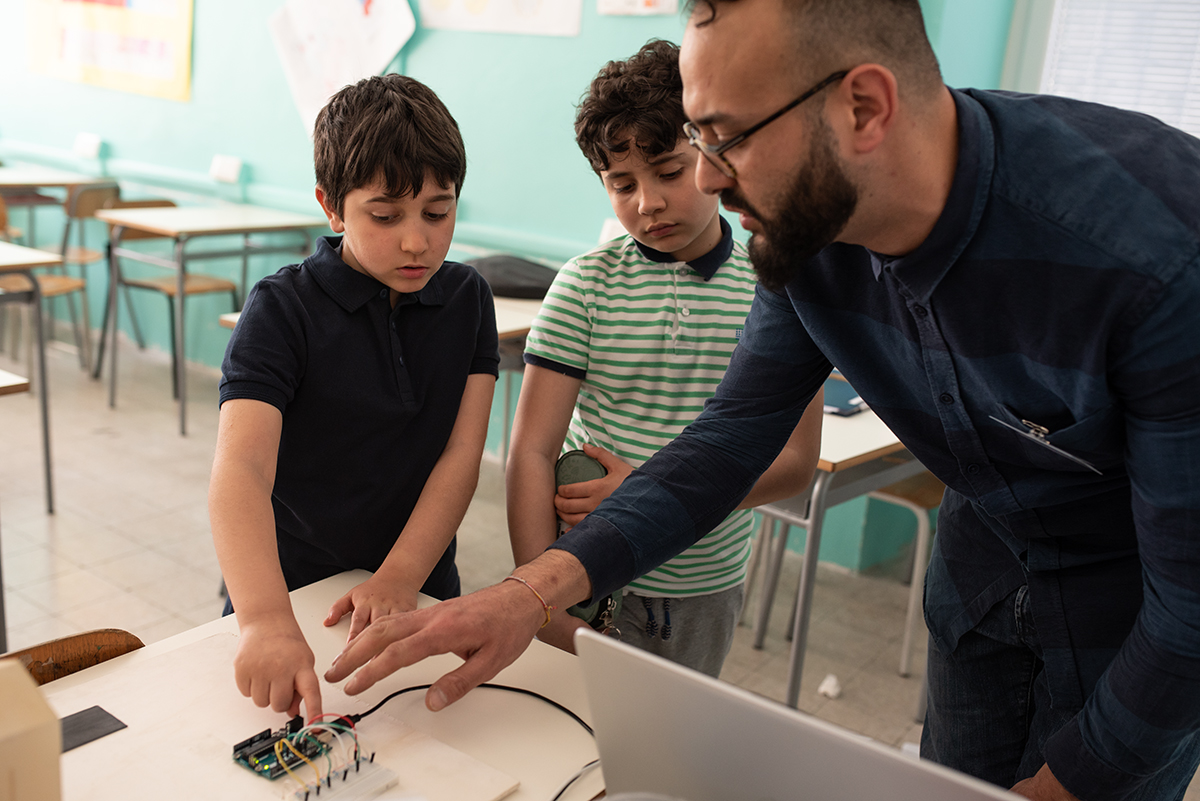 Due studenti e un docente lavorano su Arduino e circuiti elettronici in classe