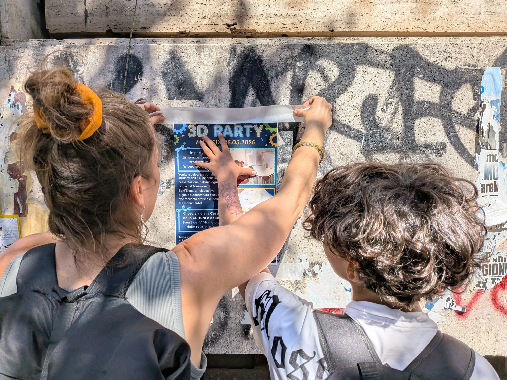 Studenti e studentesse affiggono nel quartiere la locandina del 3D Party finale